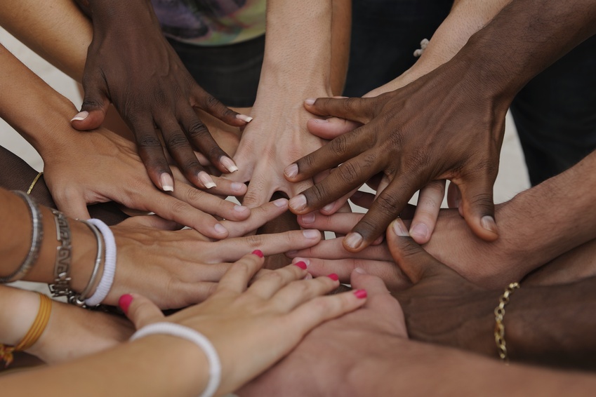 Many hands together: group of people joining hands